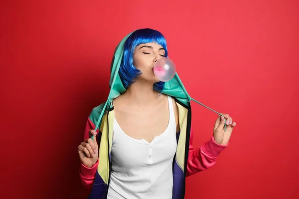 Elegante Jovem Mulher Colorido Peruca Soprando Bubblegum Fundo Vermelho — Fotografia de Stock