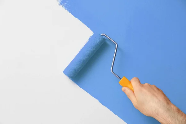 Homem Aplicando Tinta Laranja Com Escova Rolo Parede Branca Close — Fotografia de Stock