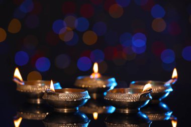 Karanlık arka planda bulanık ışıklarla aydınlatılmış diyadalar, metin için boşluk. Diwali lambaları