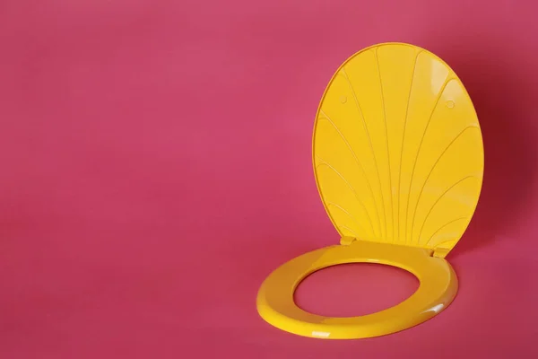 Нове Жовте Пластикове Сидіння Туалету Рожевому Фоні Простір Тексту — стокове фото