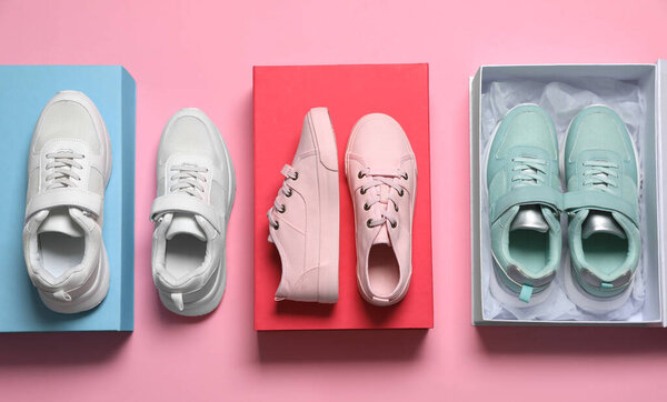 Flat lay composition with different stylish sports shoes on pink background