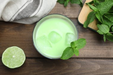 Yeşil yapraklı nefis nane likörü ve ahşap masada buz küpleri, düz yatıyordu.