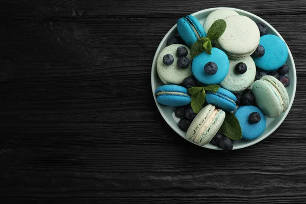Deliciosos Macarons Hortelã Mirtilos Tigela Mesa Madeira Preta Vista Superior — Fotografia de Stock