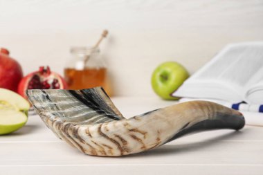 Shofar ve diğer Rosh Hashanah bayram özellikleri beyaz tahta masa üzerindedir.