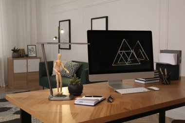 Işık odasındaki ahşap masanın üzerinde bilgisayar olan işyeri. Modern iç tasarım