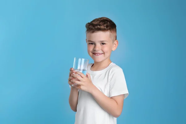 Söt Liten Pojke Med Glas Vatten Ljusblå Bakgrund — Stockfoto