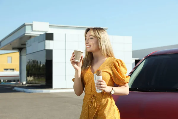 Hermosa Joven Con Perro Caliente Beber Café Cerca Coche Gasolinera — Foto de Stock