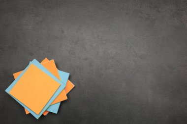 Gri taş masadaki renkli çıkartma yığını, üst manzara. Metin için boşluk
