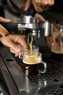 Barista profesyonel kahve makinesi kullanarak espresso yapıyor, yakın plan.