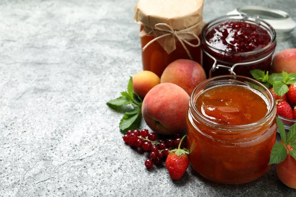 Vasi Con Marmellate Diverse Frutta Fresca Sul Tavolo Grigio Spazio — Foto Stock