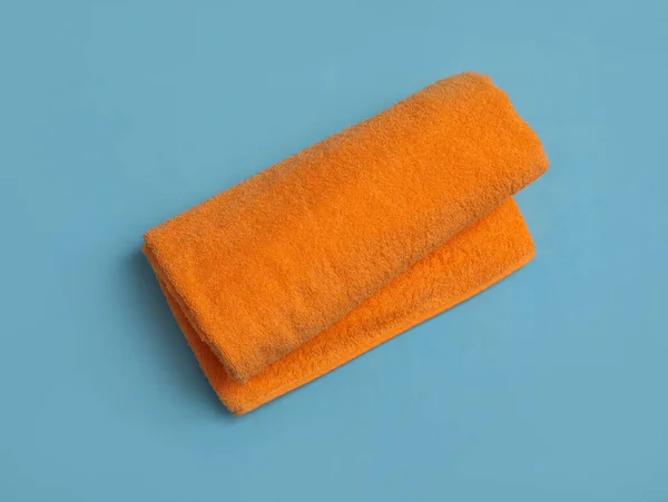 薄い青の背景にオレンジ色のビーチタオルを巻き トップビュー — ストック写真