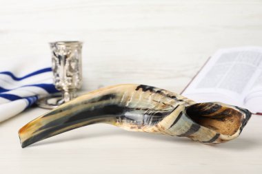 Shofar ve diğer Rosh Hashanah bayram özellikleri beyaz tahta masa üzerindedir.