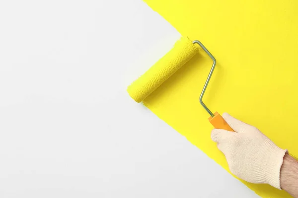 Homem Aplicando Tinta Laranja Com Escova Rolo Parede Branca Close — Fotografia de Stock