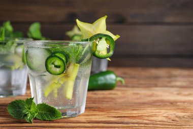 Baharatlı kokteyl, jalapeno, karambola ve ahşap masada nane. Metin için boşluk