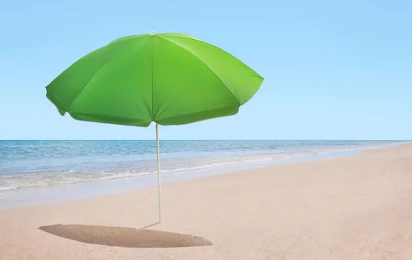 Open big beach umbrella on sandy coast