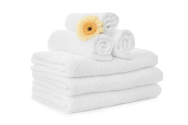 Beyaz arka planda Gerbera olan temiz havlular.