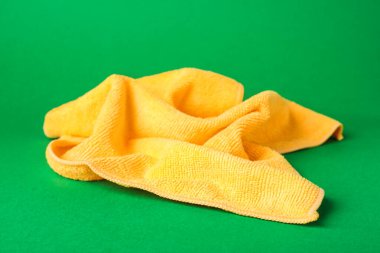 Yeşil arkaplanda turuncu mikrofiber kumaş, yakın plan.