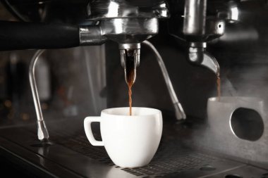 Profesyonel kahve makinesi kullanarak taze aromatik espresso yapıyorum.