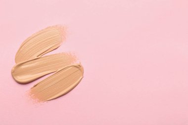 Pembe arka planda sıvı deri örneği, üst manzara. Metin için boşluk