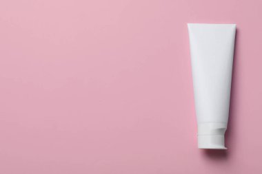 Pembe arka planda boş diş macunu tüpü, üst manzara. Metin için boşluk