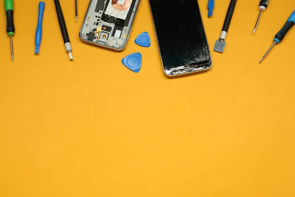 Κατεστραμμένο Smartphone Και Σετ Εργαλείων Επισκευής Πορτοκαλί Φόντο Επίπεδη Lay — Φωτογραφία Αρχείου