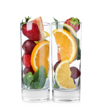 Farklı bir bütüne sahip bardaklar ve beyaz arka planda meyve kesimi