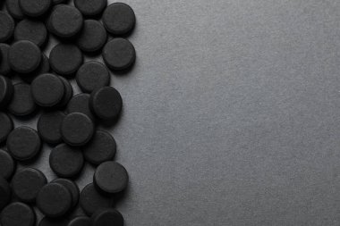 Gri arka planda aktif kömür hapları, mesaj için yeri olan düz yatış. Etkili sorbent