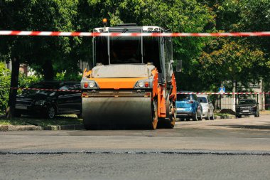 Şehir caddesinde çalışan bir patenci. Yol onarımı