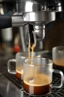 Profesyonel kahve makinesi kullanarak taze aromatik espresso yapıyorum.