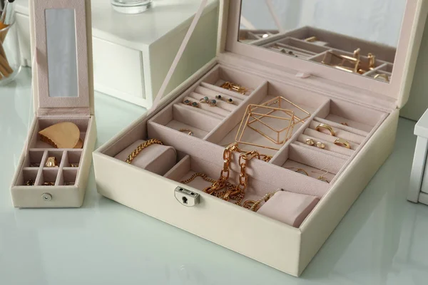 白色梳妆台上有时髦的金黄色小饰品的珠宝盒 — 图库照片