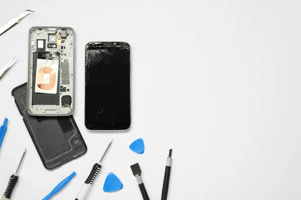 Κατεστραμμένο Smartphone Και Εργαλείο Επισκευής Που Λευκό Φόντο Επίπεδη Lay — Φωτογραφία Αρχείου