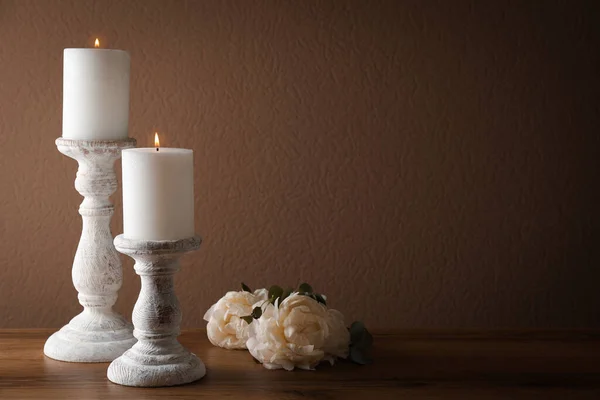 木製のテーブルの上に燃えるキャンドルや花とエレガントなキャンドルスティック テキストのスペース — ストック写真