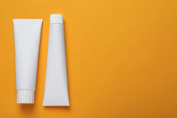 Blank Tubes Toothpaste Orange Background Flat Lay Space Text — Stock Photo, Image
