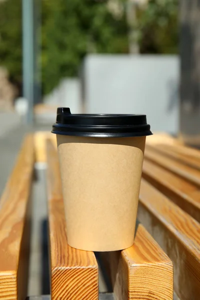 户外木制长椅上装有塑料盖子的外带纸杯咖啡 — 图库照片
