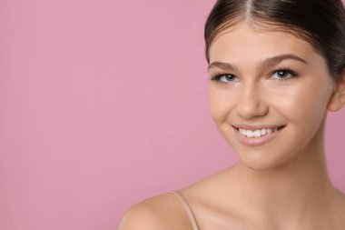 Pembe arka planda güzel bir kız, mesaj için yer var. Güzel bir yüz, pürüzsüz bir ten.