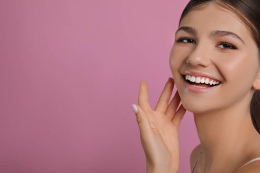 Pembe arka planda güzel bir kız, mesaj için yer var. Güzel bir yüz, pürüzsüz bir ten.