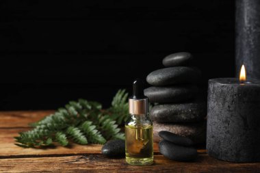 Ahşap masa üzerinde gerekli yağ ve spa taşlarıyla kompozisyon
