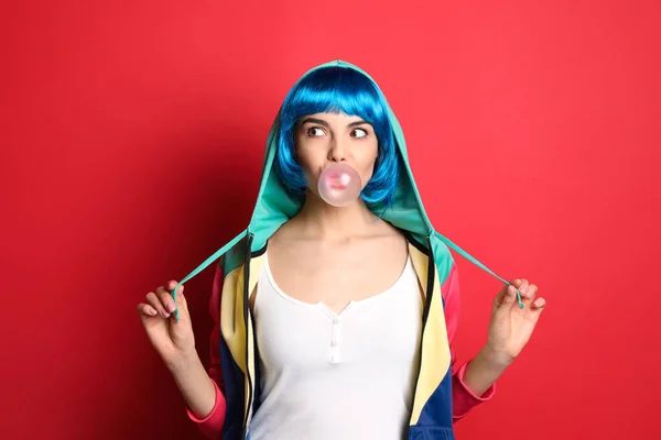 Elegante Jovem Mulher Colorido Peruca Soprando Bubblegum Fundo Vermelho — Fotografia de Stock