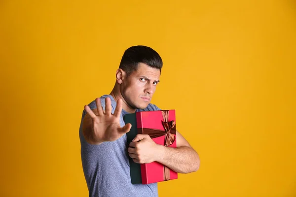 Greedy Man Hiding Gift Box Yellow Background — Stock Photo, Image