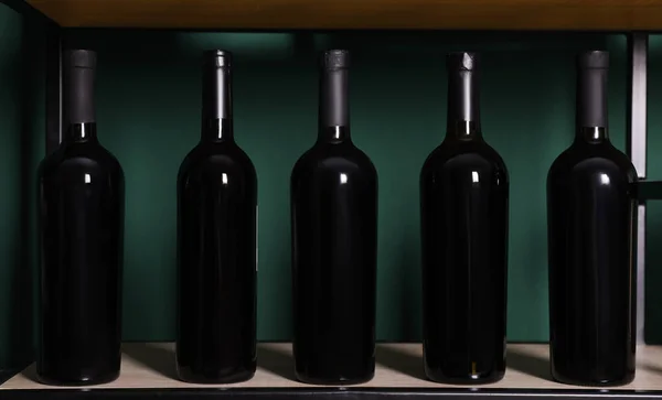 Flessen Wijn Plank Buurt Van Groene Muur — Stockfoto