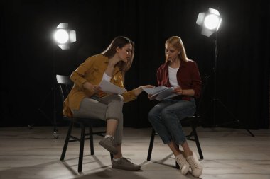 Tiyatroda prova sırasında senaryolarını okuyan profesyonel aktrisler.