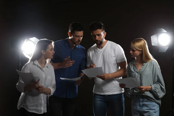 Professional actors reading their scripts during rehearsal in theatre