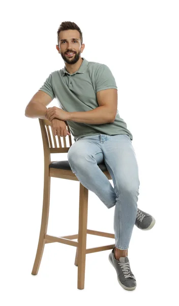 Schöner Mann Sitzt Auf Hocker Vor Weißem Hintergrund — Stockfoto
