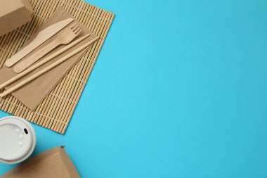 Turkuaz zemin üzerinde düz kağıt ve ahşap masa takımı, metin için boşluk. Çevre dostu yaşam tarzı