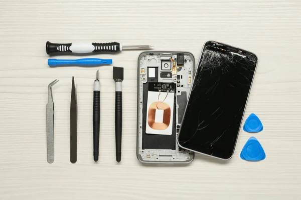 Κατεστραμμένο Smartphone Και Σετ Εργαλείων Επισκευής Λευκό Ξύλινο Φόντο Επίπεδη — Φωτογραφία Αρχείου