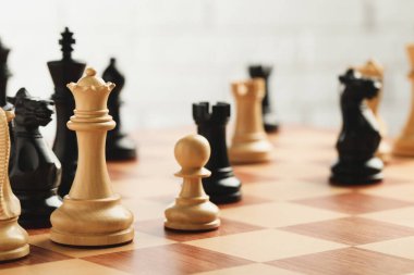 Açık arkaplanda oyun taşları olan satranç tahtası