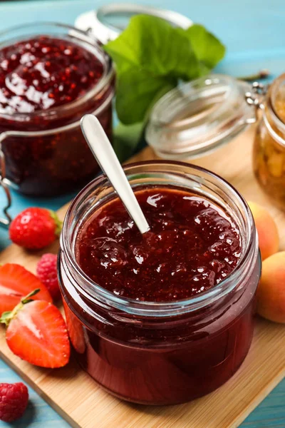 Gläser Mit Verschiedenen Marmeladen Und Frischen Früchten Auf Hellblauem Holztisch — Stockfoto