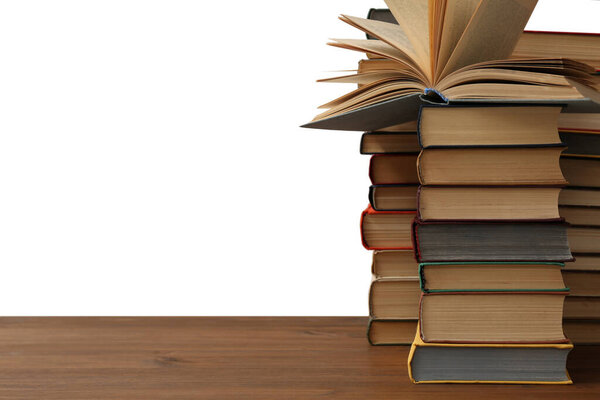 Много книг на деревянном столе на белом фоне. Библиотечный материал