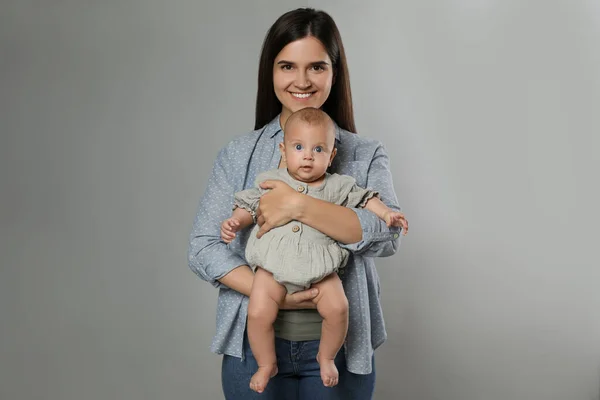 Mooie Moeder Met Haar Schattige Baby Grijze Achtergrond — Stockfoto