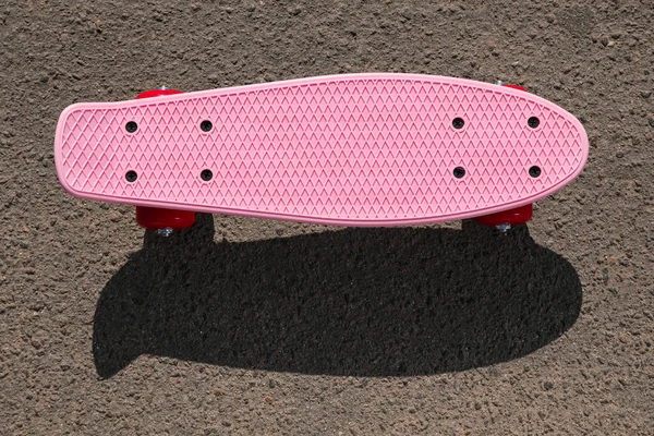 Современный Розовый Скейтборд Красными Колесами Асфальтированной Дороге Открытом Воздухе Вид — стоковое фото